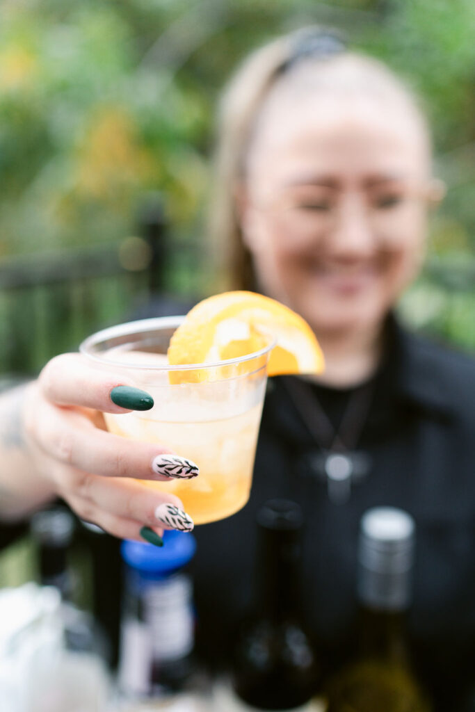 Bartender offering mixed drink to wedding guest